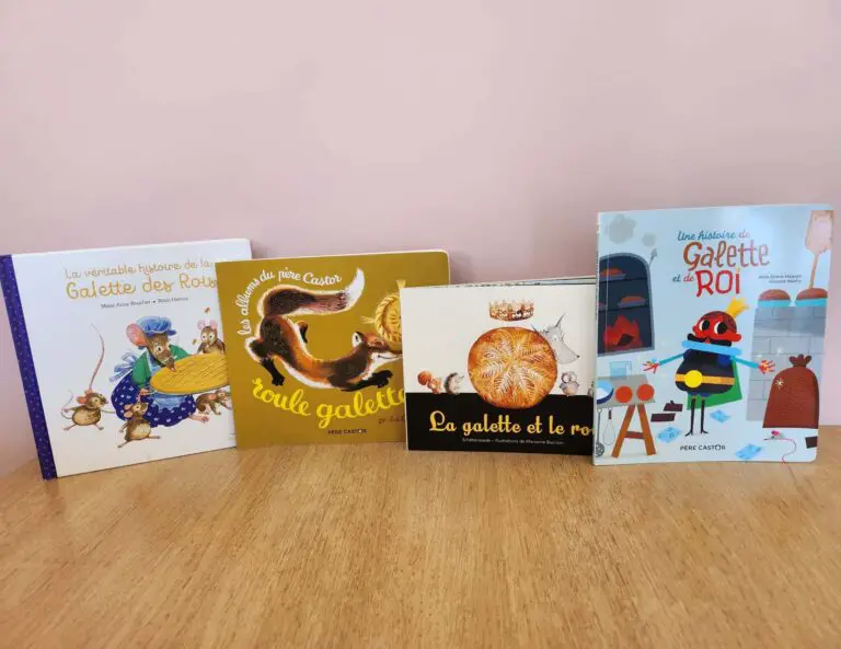 Quatre livres pour enfants sur la Galette des Rois, disposés sur une table en bois avec un fond rose.