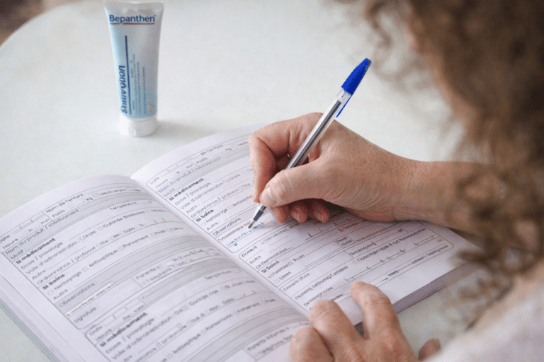 Assistante maternelle remplissant un registre de médicaments avec suivi des soins